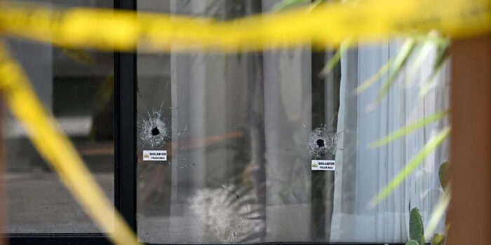 Lubang peluru di kaca jendela vila di Bali, lokasi penembakan yang menewaskan turis asal Australia. Terlihat garis polisi masih terpasang di sekitar tempat kejadian.