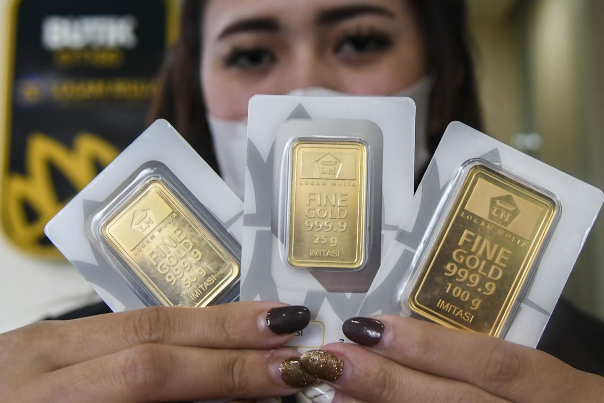 Wanita menunjukkan emas batangan Logam Mulia Emas Antam dari ukuran 25 gram hingga 100 gram di butik resmi